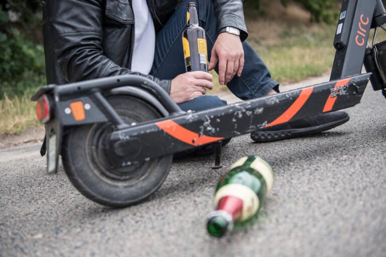 Alkoholkonsum neben einem stehenden E-Scooter