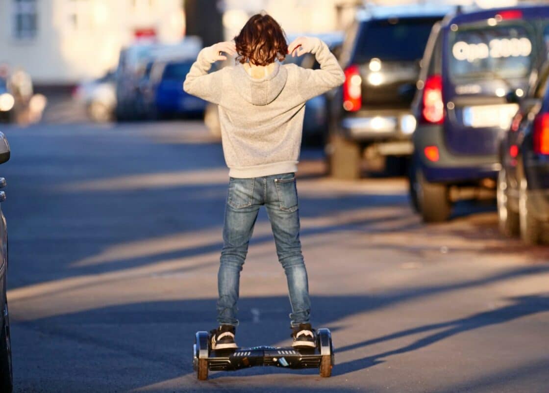 Junge faehrt Hoverboard auf der Strasse