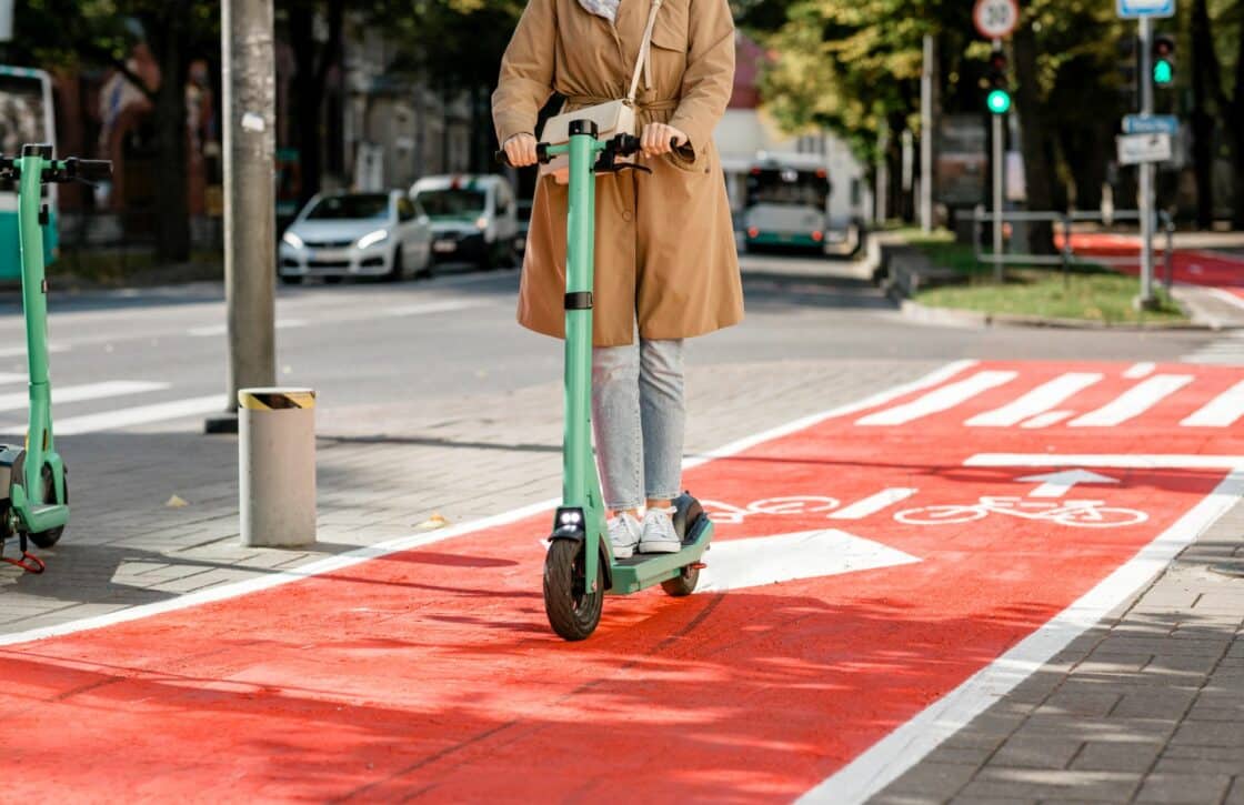 Frau mit einem E-Scooter auf dem Radweg