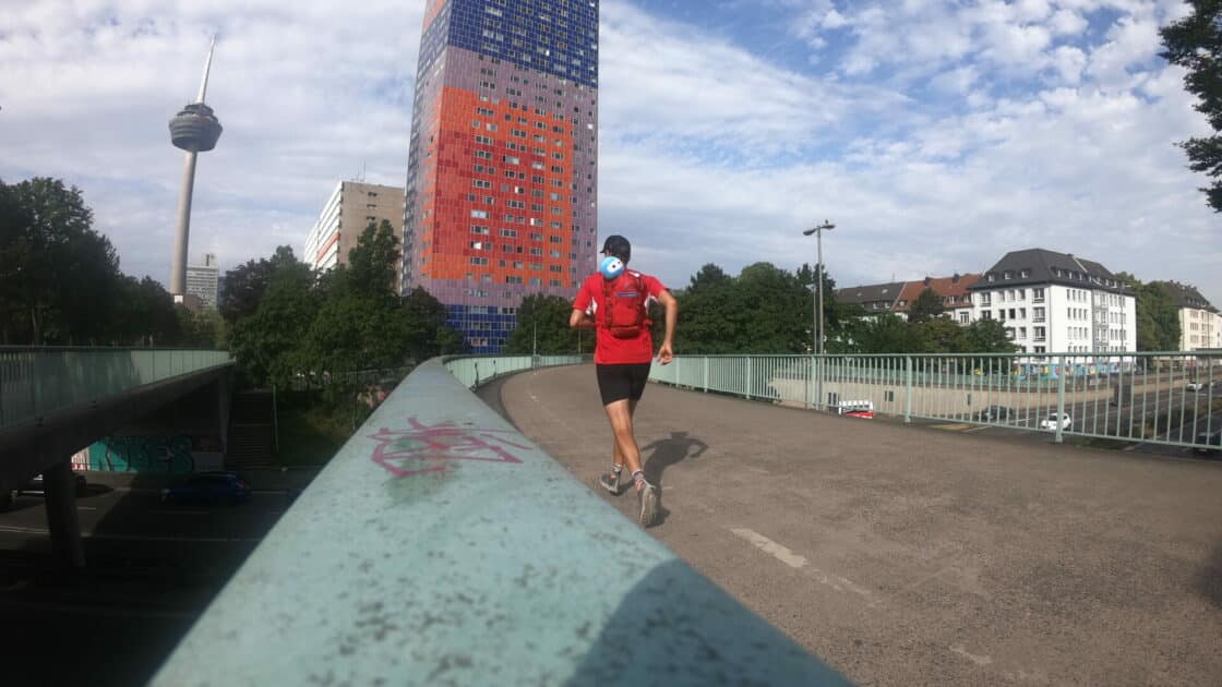 Ein Jogger läuft in Köln über eine Brücke