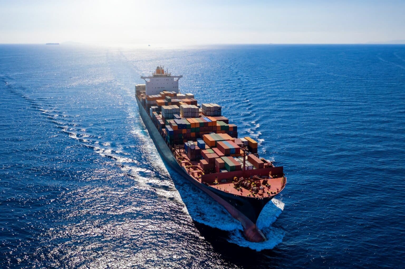 Klimaneutrale Schifffahrt: Luftaufnahme eines beladenen Containerschiffes bei voller Fahrt