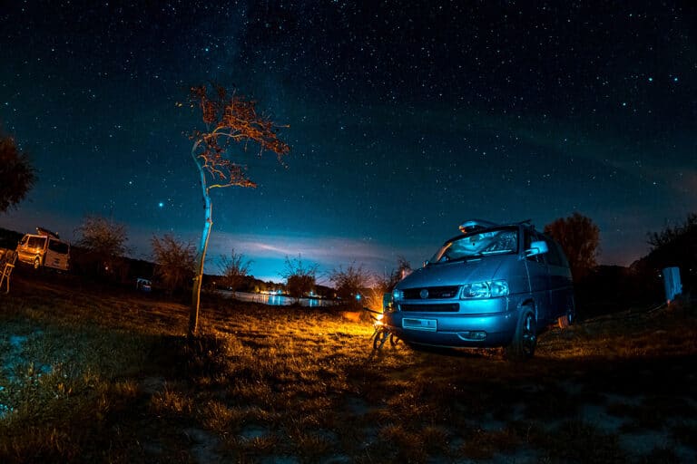 Ein Bulli bei Nacht auf einem Campingplatz
