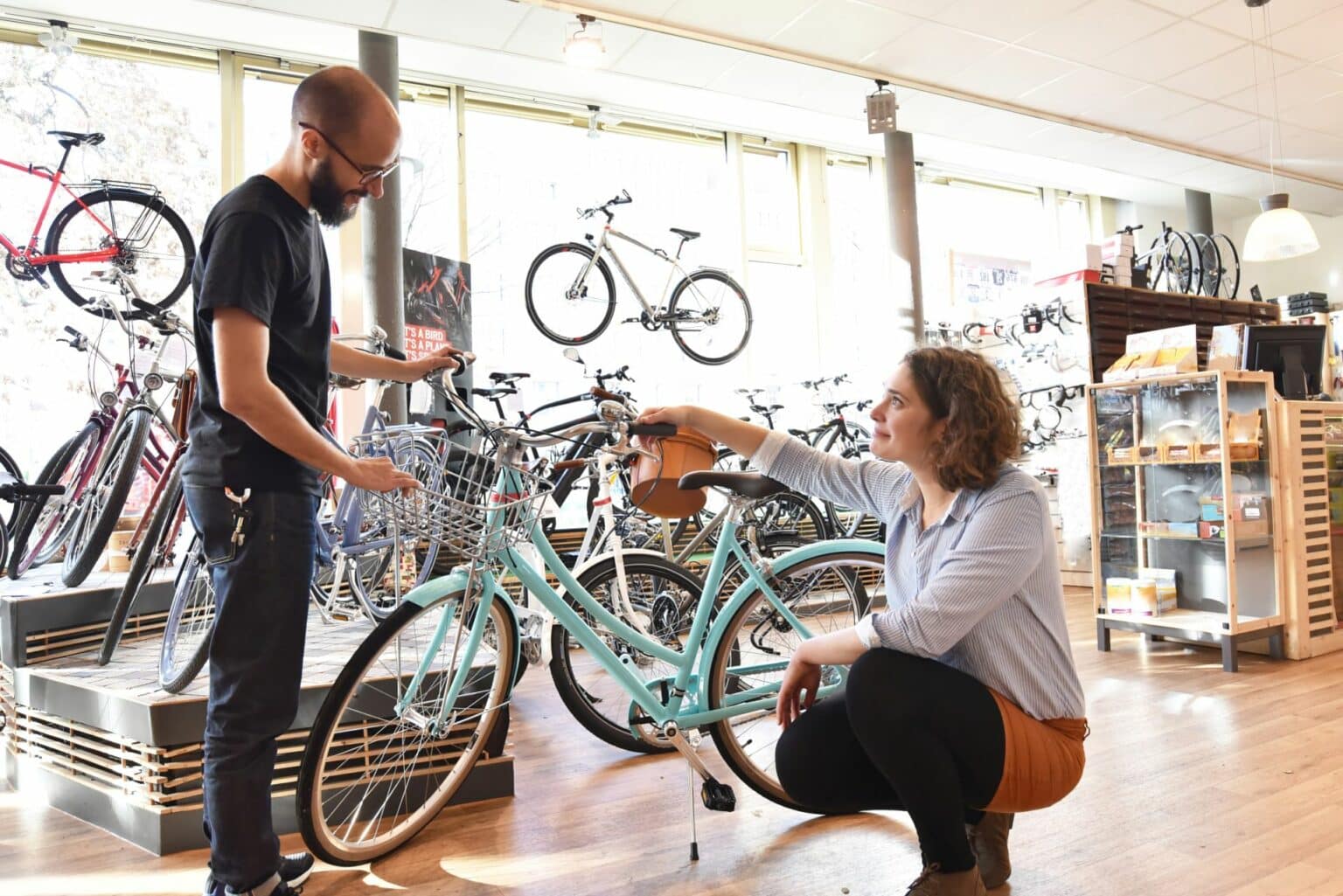 Eine Verkäuferin berät einen Kunden in einem Fahrrad-Geschäft