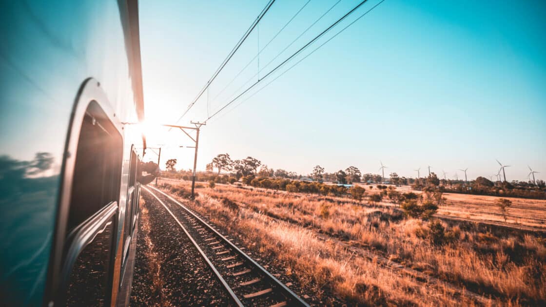 Blick aus einem Zug auf Gleise gegen die Sonne